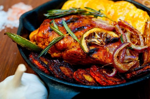 Roasted grilled BBQ chicken breast with herbs and spices rustic style on iron skillet