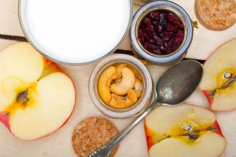 Healthy breakfast ingredients milk oat cashew nuts dried cramberry craisinns