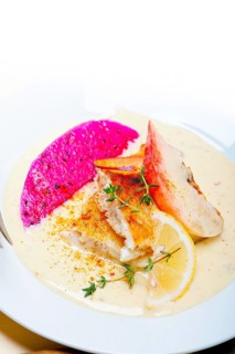 Sea bream orata fillet butter pan fried with fresh peach prune and dragonfruit slices thyme on top