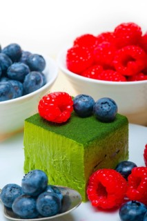 Green tea matcha mousse cake with raspberries and blueberries on top