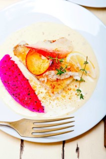 Sea bream orata fillet butter pan fried with fresh peach prune and dragonfruit slices thyme on top
