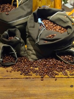 Coffee beans on bags over rustic wood background