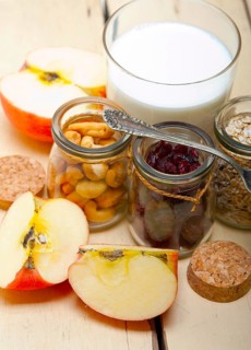 Healthy breakfast ingredients milk oat cashew nuts dried cramberry craisinns