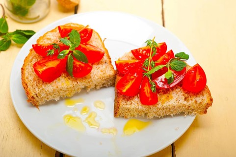 Italian tomato bruschetta with thyme and mint leaves