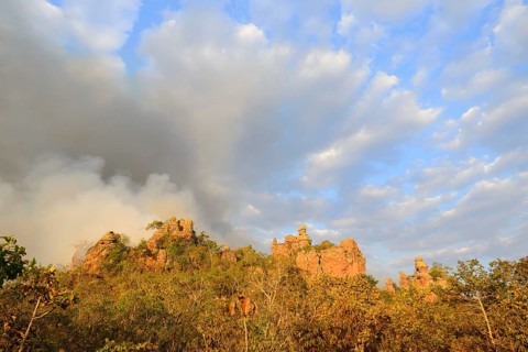 Bizarre rock formation and clouds of smoke during a bushfire