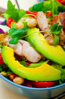 Fresh and healthy Chicken Avocado salad over rustic wood table