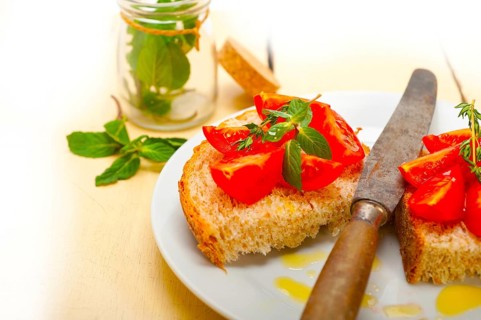 Italian tomato bruschetta with thyme and mint leaves