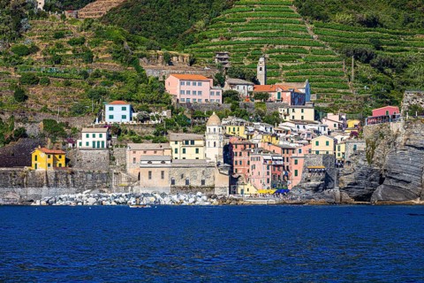 The village of Vernazza with its churches and pastel-coloured houses built into the hillside