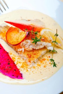 Sea bream orata fillet butter pan fried with fresh peach prune and dragonfruit slices thyme on top