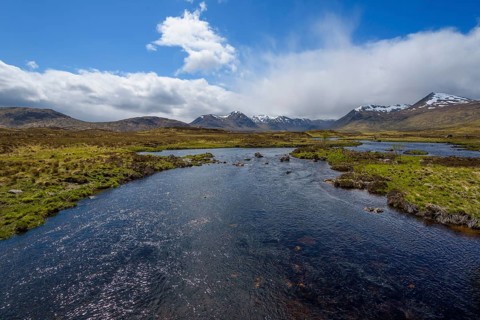 River in moor landscape with cloudy sky