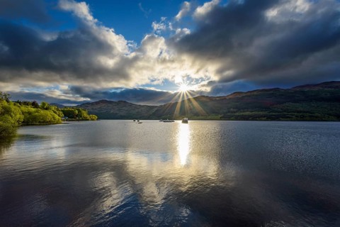 Lake with dramatic clouds and sun in spring