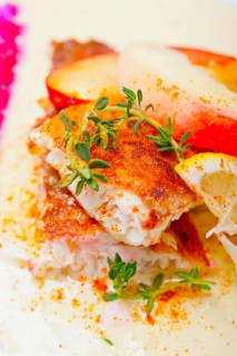 Sea bream orata fillet butter pan fried with fresh peach prune and dragonfruit slices thyme on top