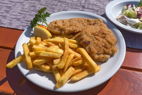 Wiener schnitzel served with french fries in a garden restaurant