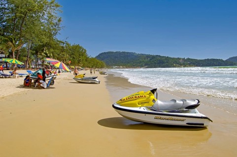 Patong Beach with umbrellas and tourists by the sea in Thailand
