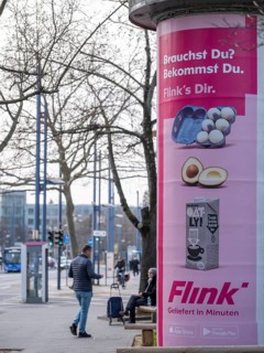 Advertisement of the delivery service Flink on an advertising pillar