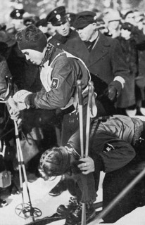 The sister helps. . ! It is Christl Cranz here unstrapping the boards for her brother Rudi after his dashing downhill run