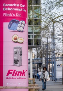 Advertisement of the delivery service Flink on an advertising pillar