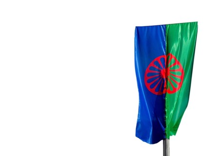 Eine Roma und Sintiflagge weht im Wind mit weissem Hintergrund