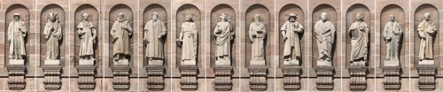 Collage of thirteen stone sculptures of historical legal scholars on the main facade of the Justice Building
