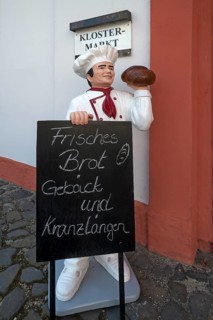 Baker's figure with offer board in front of the convent shop