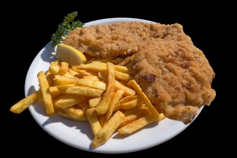 Wiener Schnitzel with french fries on a black background