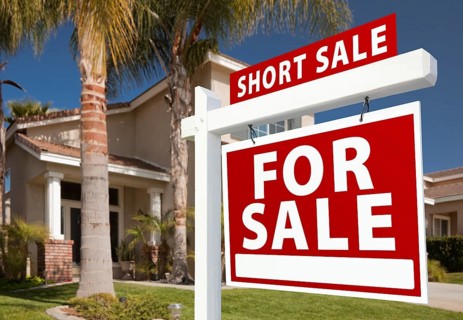 Short sale home for sale real estate sign and house