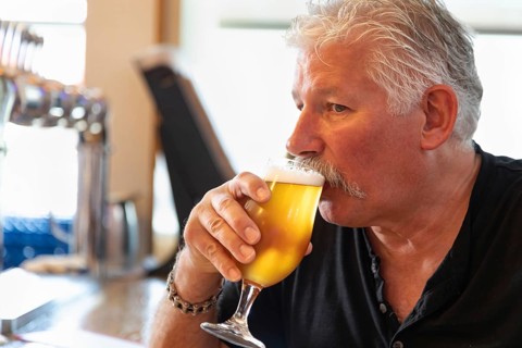 Handsome man tasting A glass of micro brew beer
