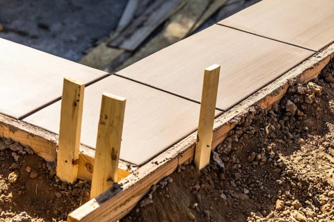 Fresh pool coping cement drying within wood framing