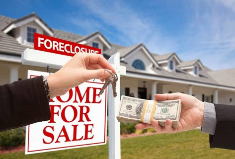 Handing over cash for house keys in front of house and foreclosure sign