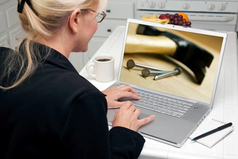 Woman in kitchen using laptop to research home improvement. screen can be easily used for your own message or picture. picture on screen is my copyright as well