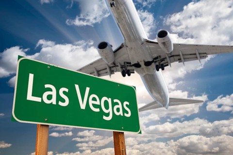 Las vegas green road sign and airplane above with dramatic blue sky and clouds