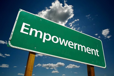 Empowerment green road sign over dramatic clouds and sky