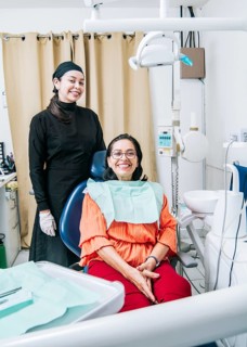 Dentist with patient smiling at camera in office