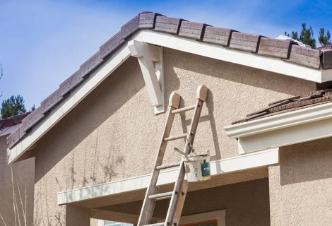 Construction ladder leaning up against A house ready for new paint