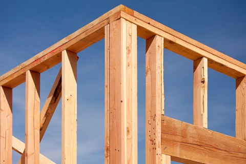 New residential home construction framing site against blue sky