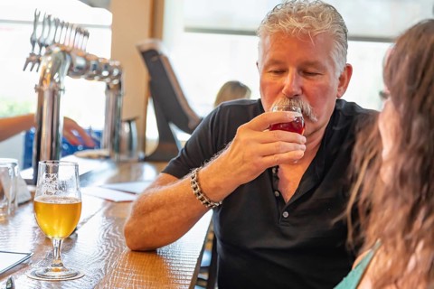 Handsome man tasting A glass of micro brew beer