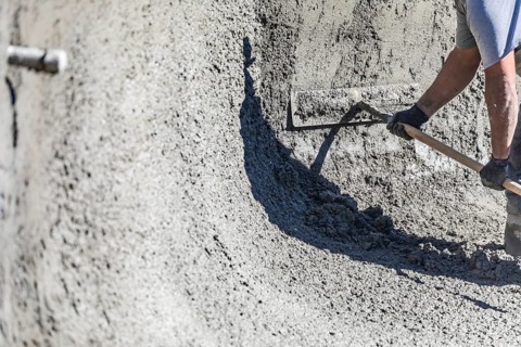 Pool construction worker working with A bullfloat on wet concrete