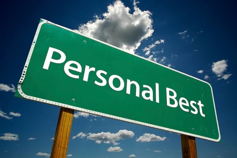 Personal best green road sign over dramatic blue sky and clouds with clipping path