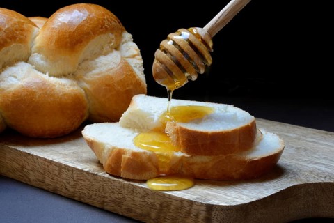 Bee honey dripping onto butter plait discs