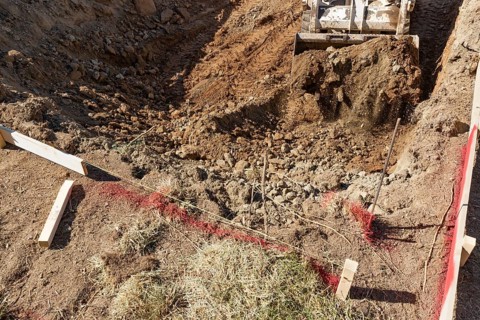 Small bulldozer digging in yard for pool installation