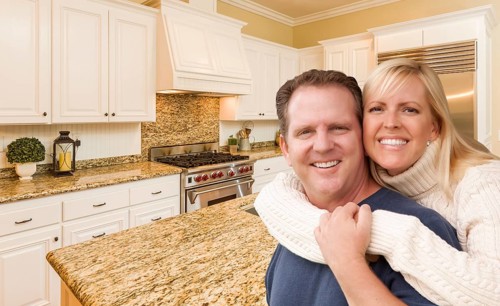 Happy couple hugging inside beautiful custom kitchen