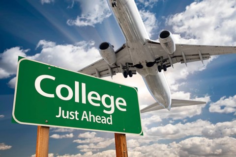 College green road sign and airplane above with dramatic blue sky and clouds
