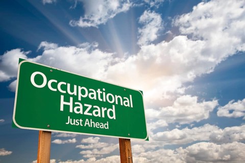 Occupational hazard green road sign with dramatic clouds and sky