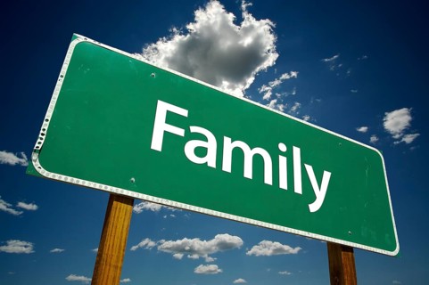Family road sign with dramatic clouds and sky