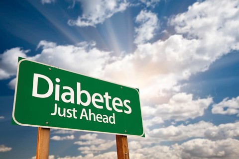 Diabetes just ahead green road sign with dramatic clouds
