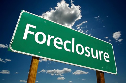Foreclosure green road sign with dramatic clouds and sky