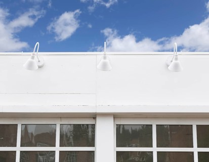 Blank building front with lamps and windows against blue sky