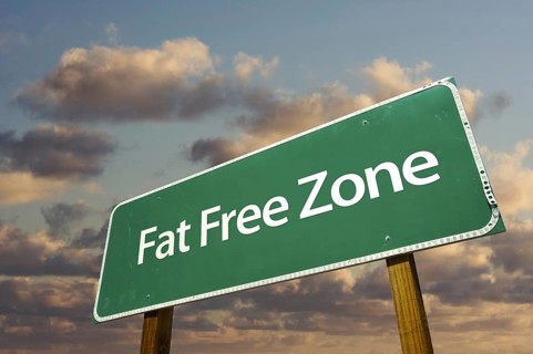 Fat free zone green road sign in front of dramatic clouds and sky