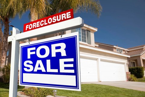 Foreclosure for sale real estate sign in front of house