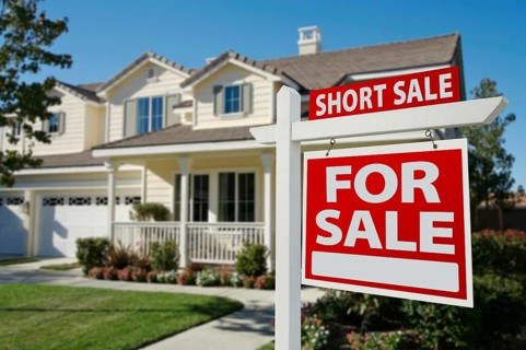 Short sale home for sale real estate sign and house